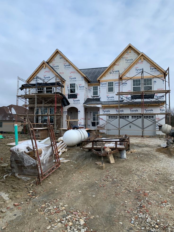 New construction home wrapped in Tyvek with scaffolding for exterior work