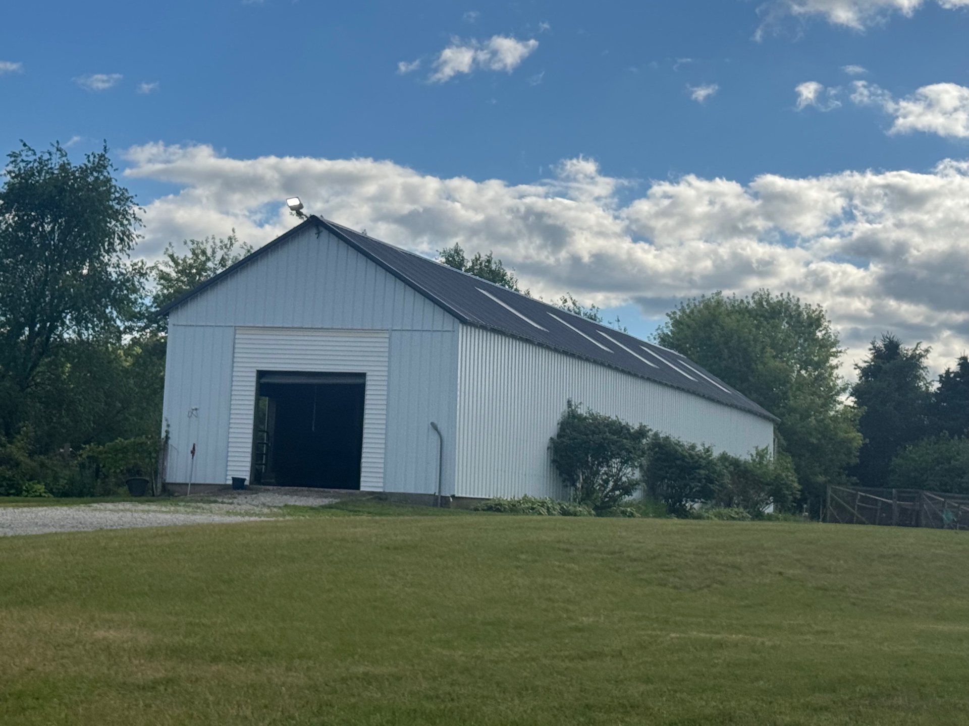 Completed white pole barn with new metal roof