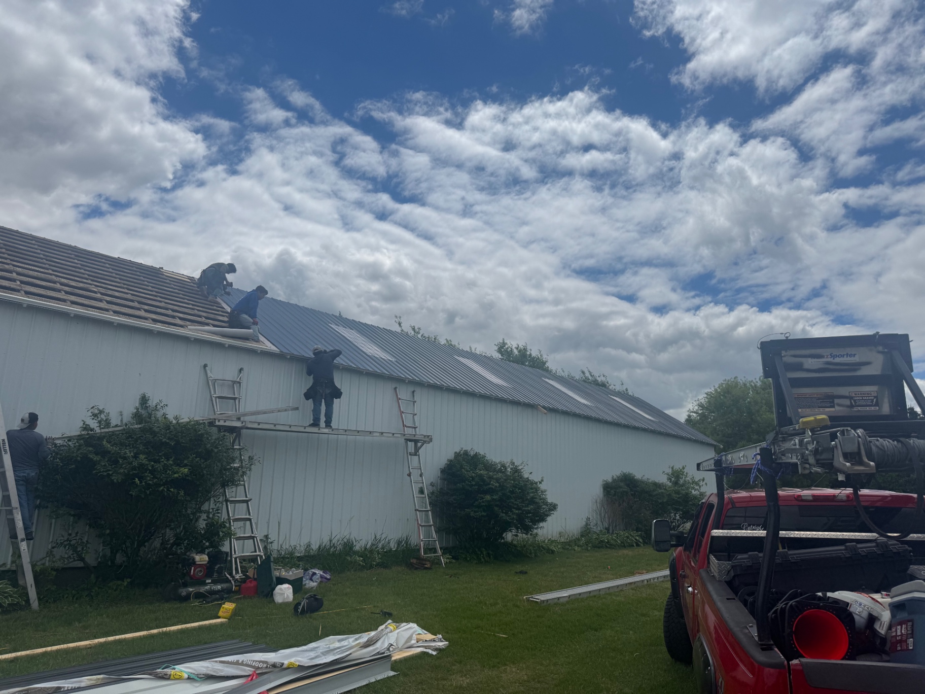 Metal roof installation on large pole barn